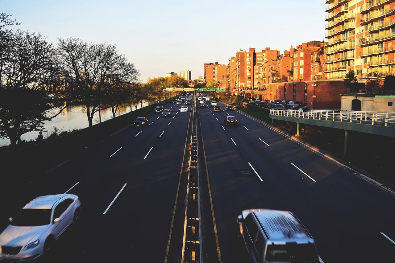 Traffic on a wide London road in late-afternoon sun