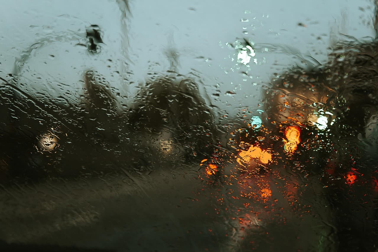 Rain on the windscreen, brake lights blurred beyond